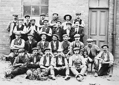 Surface workers pictured outside the pay office at Fanny Pit in 1911<br>There are no names of the men pictured above, is it possible that one of the faces staring out of the photograph could be Ernest?